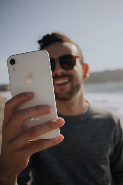 Photo d’un homme qui tient un iPhone et qui rit.