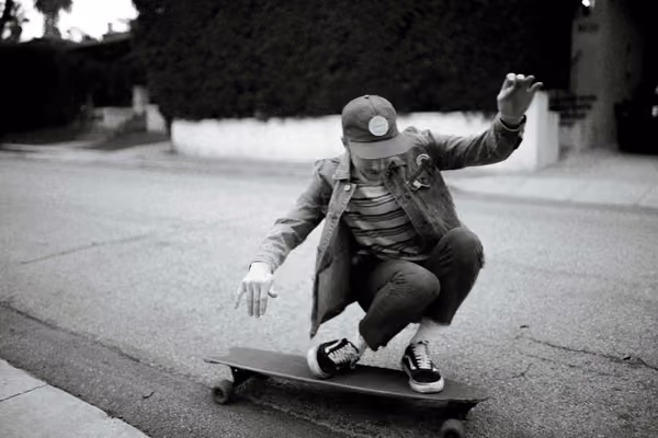 Ein Mann balanciert auf einem Longboard