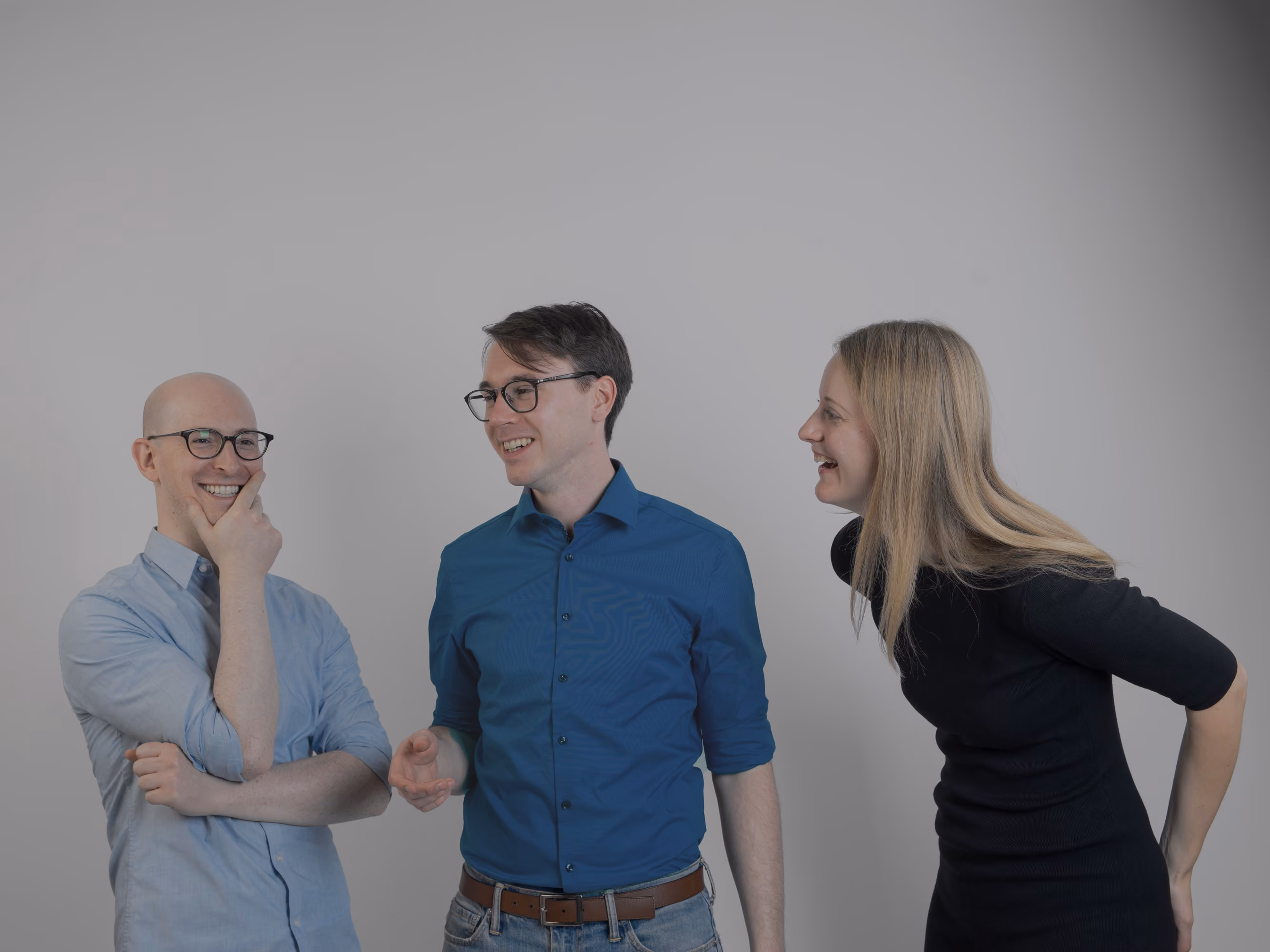 Gabriel Reimers, Julius Peinelt und Anna Neovesky lachend vor grauem Hintergrund