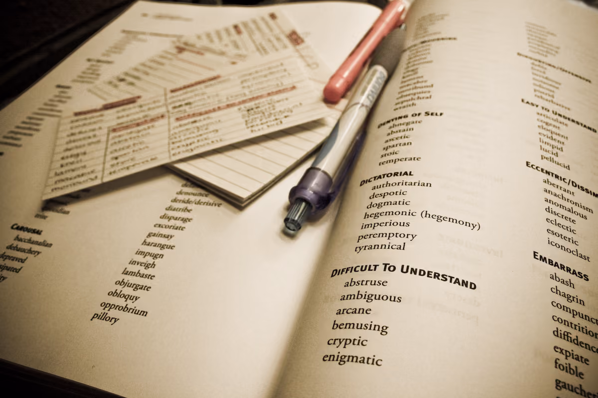 Flashcards écrites à la main posées sur un livre de vocabulaire